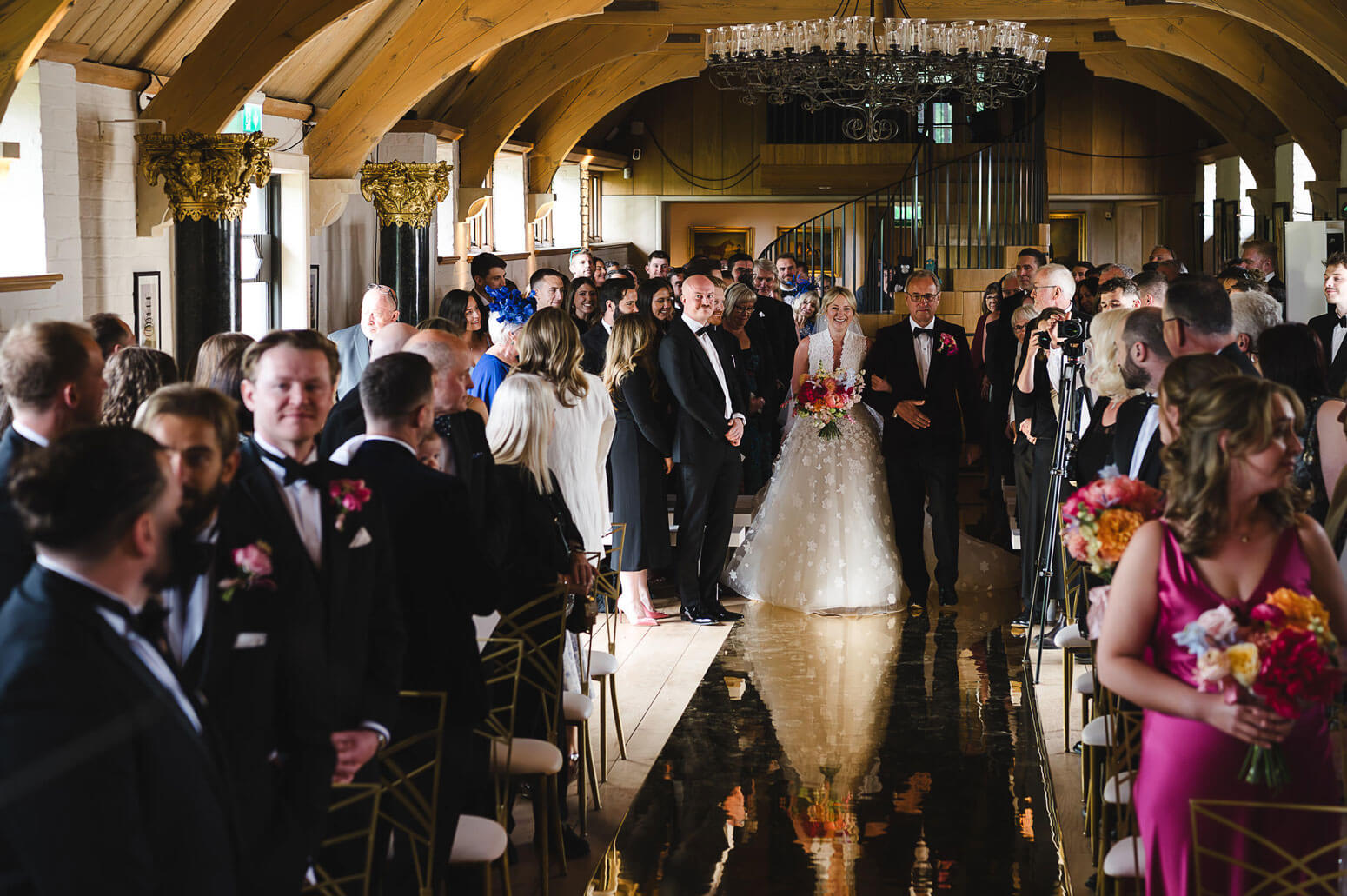 Wedding reception with guests in formal attire in a elegant hall.