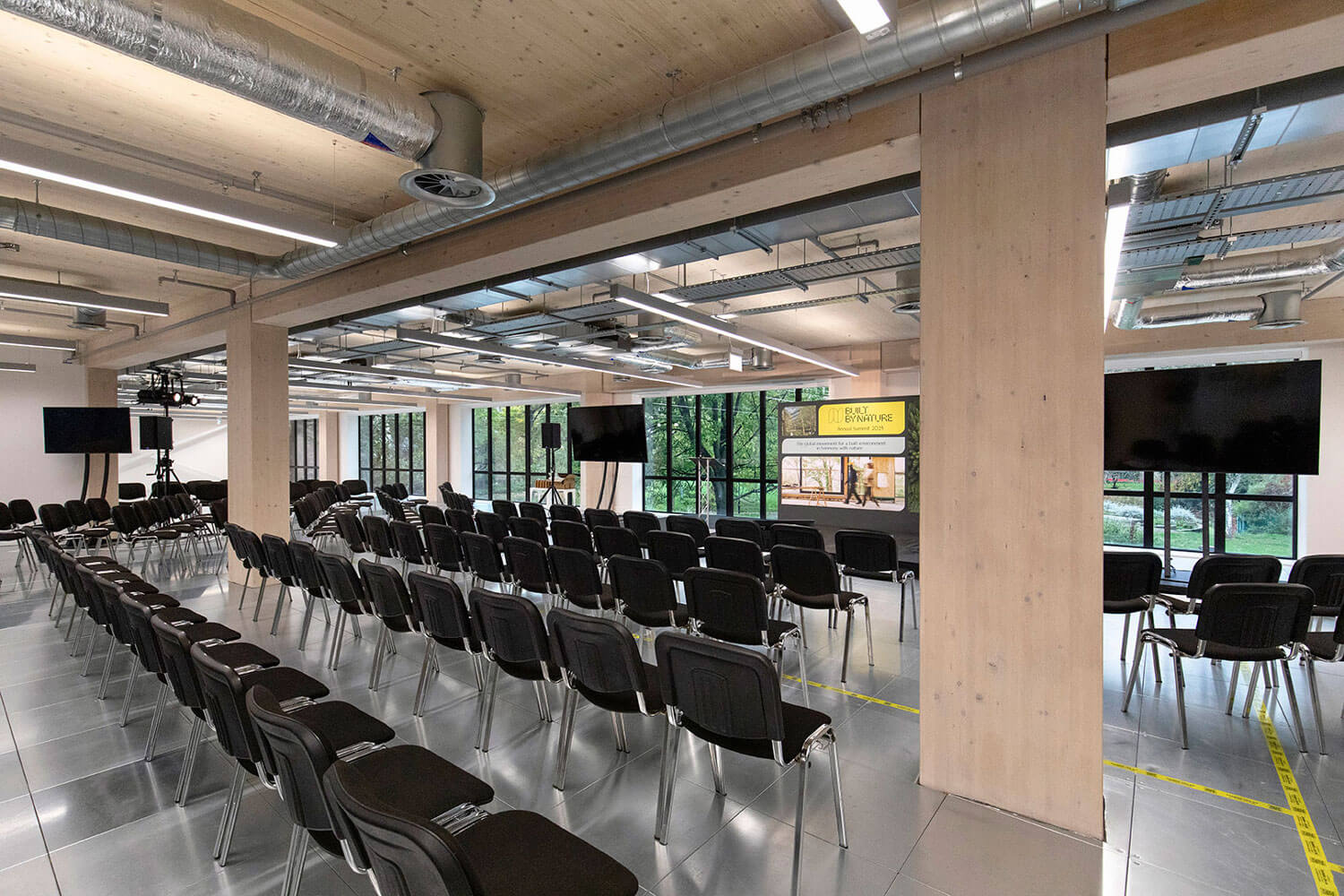 Modern conference room with rows of chairs and large windows.