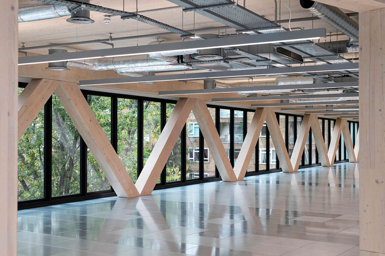 Modern indoor architectural space with wooden timber structural beams and large windows