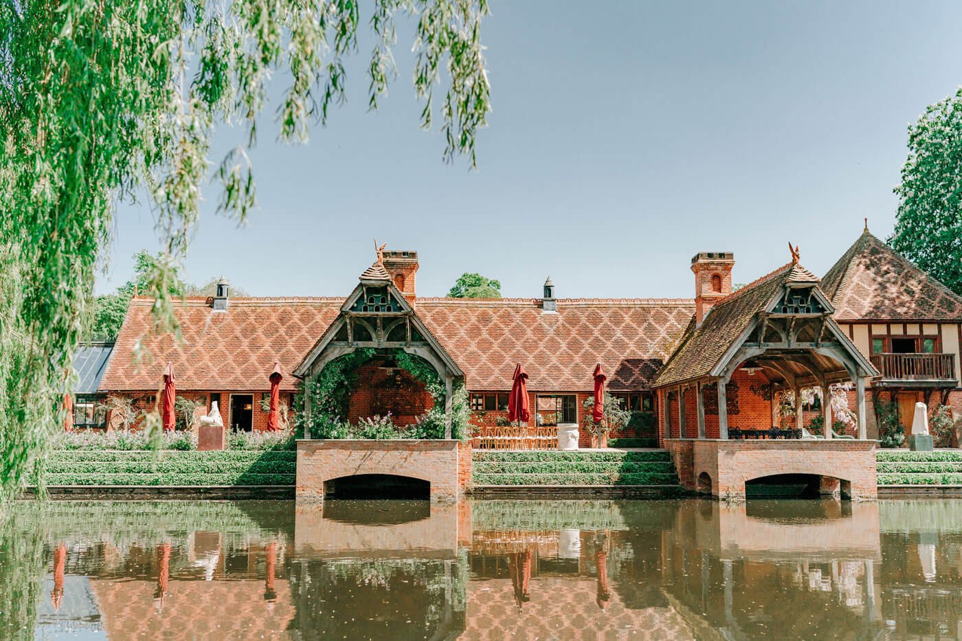 the old dairy at waddesdon with lake and willow tree
