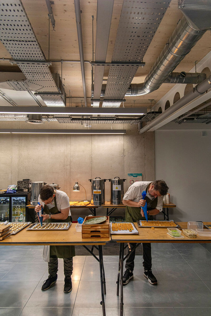Two chefs preparing plant based canapes behind the scenes at a corporate event